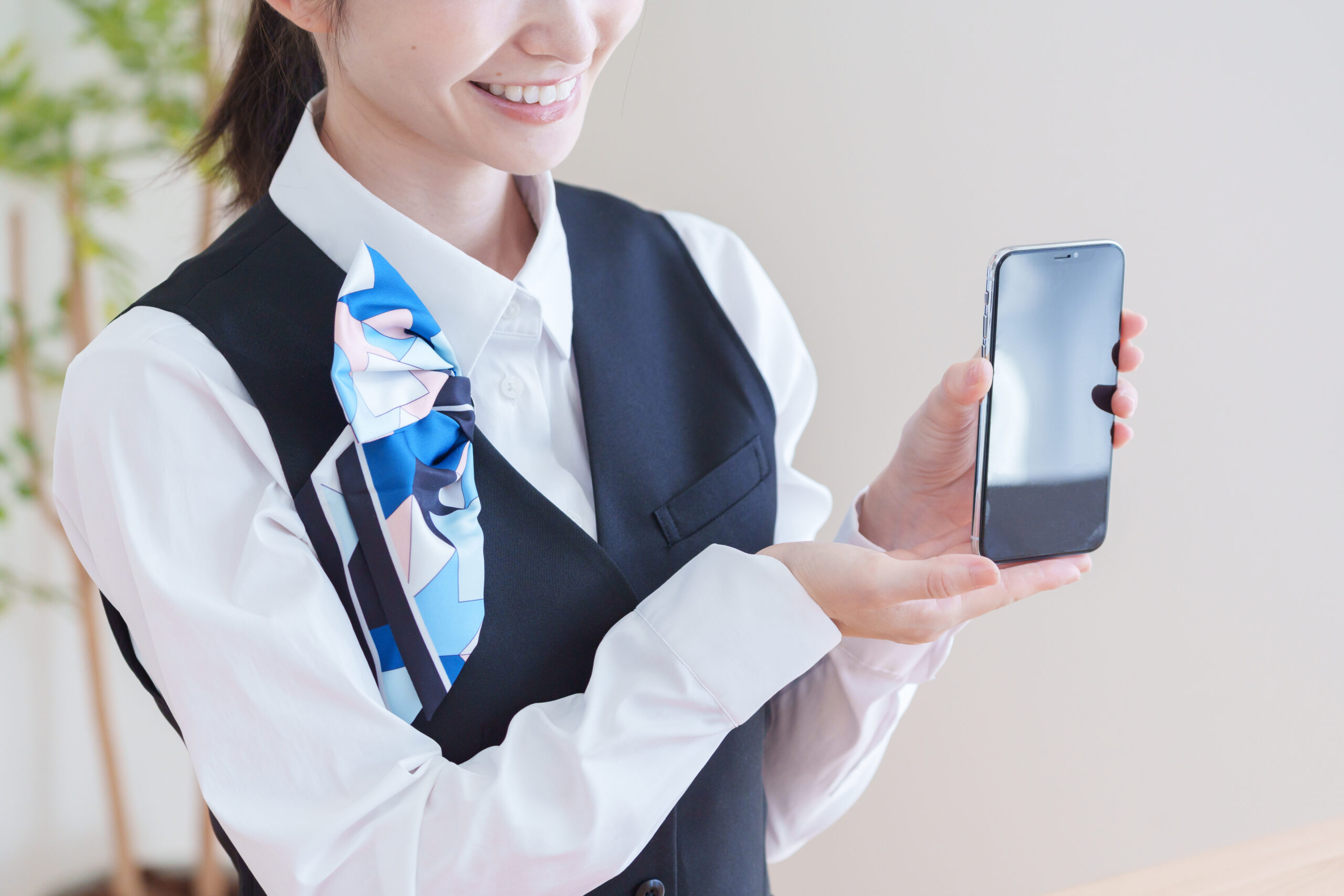 スマホを見せる女性スタッフ